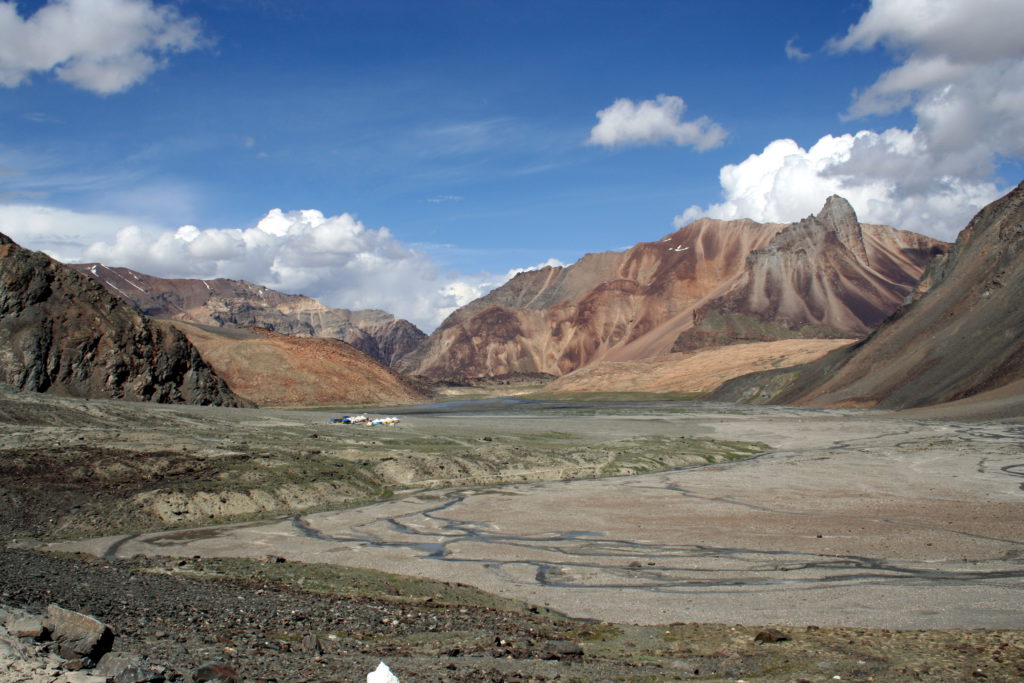 Nachdem die Pässe zwischen Himachal Pradesh und Jammu-Kaschmir überwunden sind, finden wir uns am Ladakhischen Hochplateau wieder. Im Osten schließt es an Tibet, im Nordwesten an das pakistanische Kaschmir und Baltistan, im Süden an Spiti und Lahaul an. Die Zeltstädte, wie hier am Bild, bieten dem Reisenden Rast, Momos (gefüllte Teigtaschen) und Chai (süßen Gewürztee mit Milch).